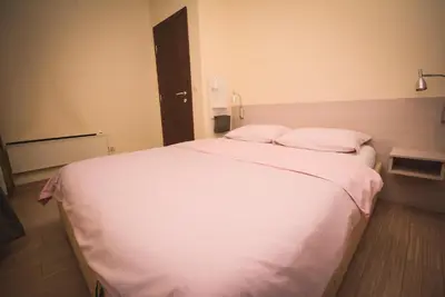 a bedroom with a large white bed with two pillows at Apartment Ilunion I in Vrnjačka Banja
