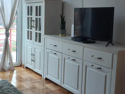 a white cabinet with a television on top of it at Le Soleil Apartman Vrnjačka Banja in Vrnjačka Banja