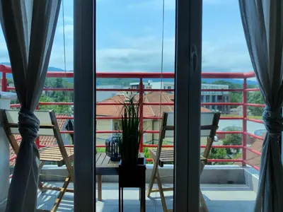 a balcony with two chairs and a table with a view at Le Soleil Apartman Vrnjačka Banja in Vrnjačka Banja