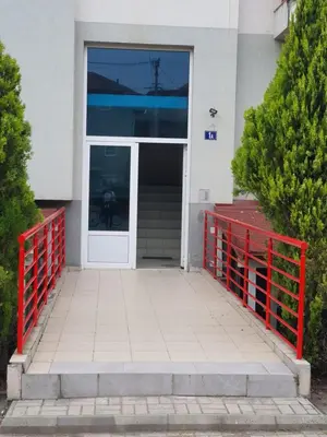 a door to a building with a red fence at Le Soleil Apartman Vrnjačka Banja in Vrnjačka Banja