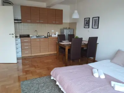 a kitchen and dining room with a table and chairs at Le Soleil Apartman Vrnjačka Banja in Vrnjačka Banja