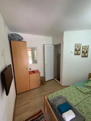 a small bedroom with a bed and a dresser and a bed at Dedovina in Soko Banja