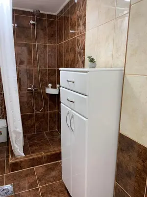 a bathroom with a white cabinet and a shower at Apartmani Bambi Sokobanja in Soko Banja