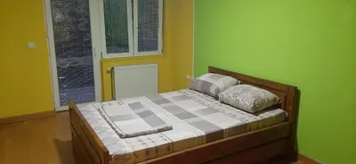a bed in a room with green walls at Greenspace in Niš