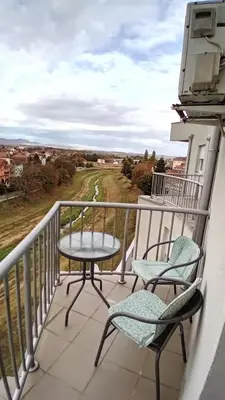 a patio with two chairs and a table on a balcony at WING 3 apartman ,,BC ,, in Jagodina