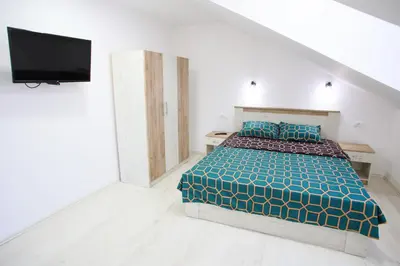 a bedroom with a bed and a flat screen tv at Apartmani Hedonist in Soko Banja