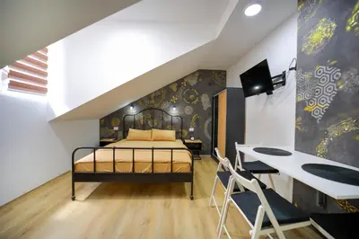 a bedroom with a bed and a desk at Apartmani Hedonist in Soko Banja
