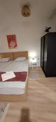 a bedroom with two beds and a black cabinet at Apartman Ana in Leskovac
