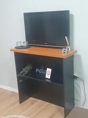 a tv on top of a black entertainment center at Apartman Ana in Leskovac