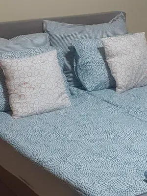 a bed with three pillows on top of it at Apartman Ana in Leskovac