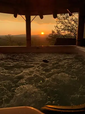 a jacuzzi tub with the sunset in the background at Boja Zalaska - kameni apartman in Jagodina