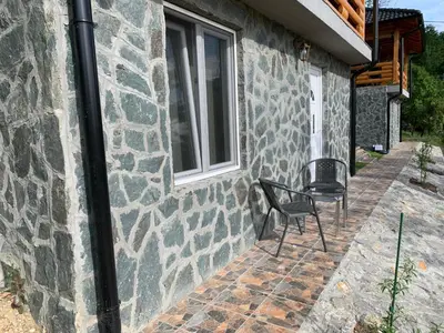 a chair sitting on a patio next to a building at Boja Zalaska - kameni apartman in Jagodina