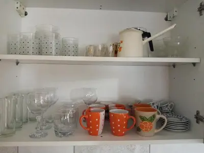a shelf with cups and glasses on it at Apartman MACA in Pirot
