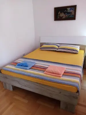 a bed with colorful pillows on top of it at Apartman MACA in Pirot