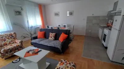 a living room with a couch and a kitchen at Apartman MACA in Pirot