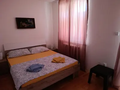 a small bedroom with a bed with two hats on it at Apartman MACA in Pirot