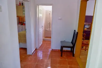 a room with a hallway with a chair and a bedroom at Šumska tajna - Radenkovac in Lipovac