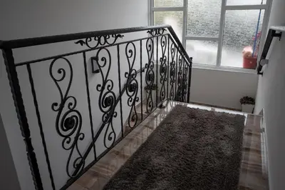a staircase with a wrought iron railing and a rug at Restoran Mijajlovic in Kuršumlija
