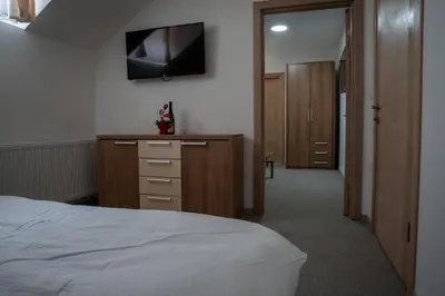 a bedroom with a bed and a television on the wall at Restoran Mijajlovic in Kuršumlija