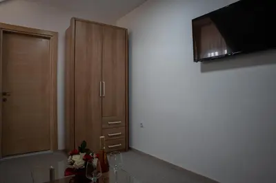 a kitchen with a wooden cabinet and a tv at Restoran Mijajlovic in Kuršumlija