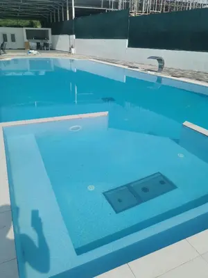 a swimming pool with a reflection of a person in the water at Restoran Mijajlovic in Kuršumlija