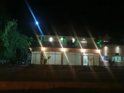 a house lit up at night with lights at Restoran Mijajlovic in Kuršumlija