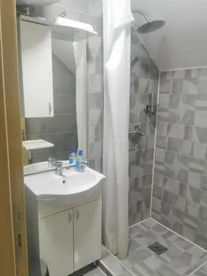a bathroom with a sink and a shower at Restoran Mijajlovic in Kuršumlija