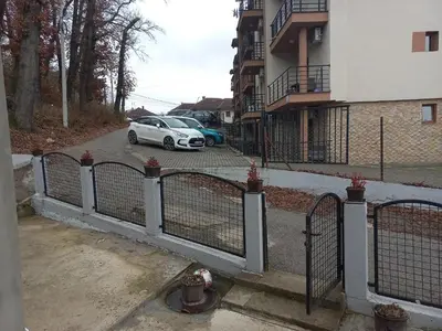 a white car parked in a parking lot next to a building at Adrijana 2 Apartmani in Vrnjačka Banja