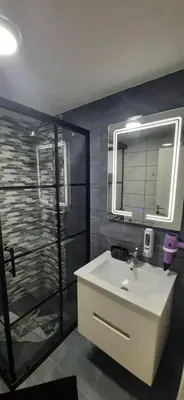 a bathroom with a sink and a shower at Adrijana 2 Apartmani in Vrnjačka Banja