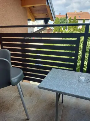 a chair and a table on a balcony at Apartmani MALINA in Vrnjačka Banja