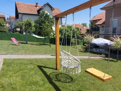 a swing set in the yard of a house at Apartmani MALINA in Vrnjačka Banja