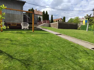 a lawn with a white bench in a yard at Apartmani MALINA in Vrnjačka Banja