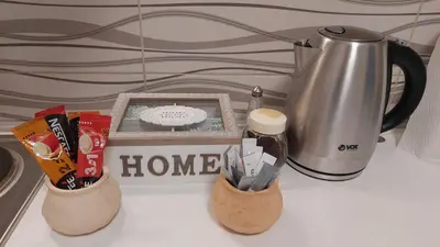 a counter with two vases with pens and a coffee pot at Apartmani MALINA in Vrnjačka Banja