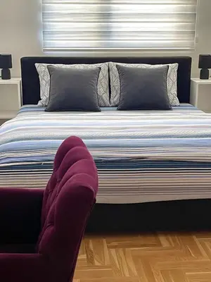 a bedroom with a large bed with a window at City Apartmani Niš in Niš