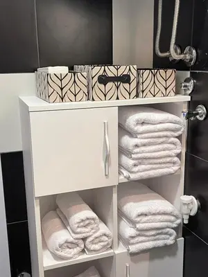 a white towel rack with towels in a bathroom at City Apartmani Niš in Niš