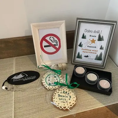 a table with a box of cookies and a sign at Falling Star Apartman Brzece in Brzeće