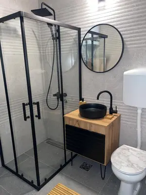 a bathroom with a shower with a sink and a mirror at Enjoyment Apartment in Niš