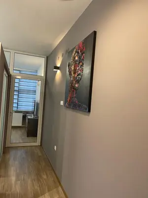a painting hanging on a wall in a room at Enjoyment Apartment in Niš