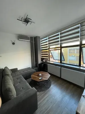 a living room with a couch and a coffee table at Enjoyment Apartment in Niš
