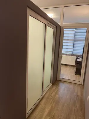 a room with sliding glass doors and a living room at Enjoyment Apartment in Niš