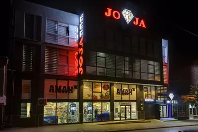 a building with a sign on the side of it at Apartmani Joja in Kuršumlija