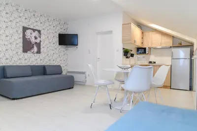 a living room with a couch and a table and chairs at Sky Lux in Soko Banja