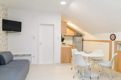 a small apartment with a white table and chairs at Sky Lux in Soko Banja