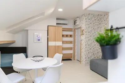 a small apartment with a white table and white chairs at Sky Lux in Soko Banja