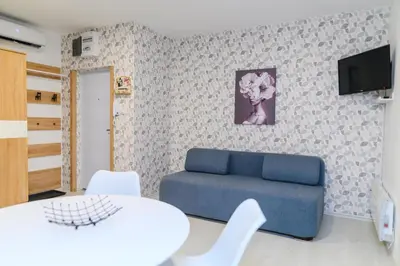 a living room with a blue couch and a tv at Sky Lux in Soko Banja