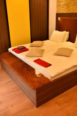a large bed with white sheets and pillows on it at Bella Superior Apartment in Kruševac