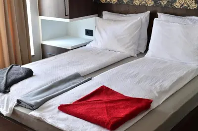a white bed with a red blanket on it at Bella Superior Studio in Kruševac