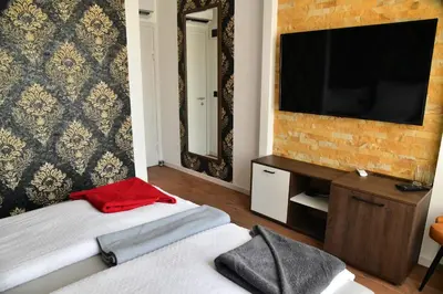 a bedroom with a bed and a television on a wall at Bella Superior Studio in Kruševac