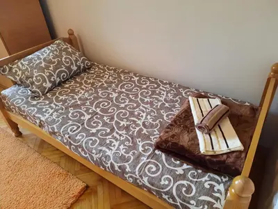 a couch with a pillow and a book on it at Apartman Lan - Free parking in Vranje