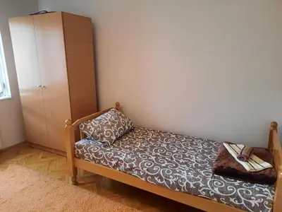 a small bedroom with a bed and a cabinet at Apartman Lan - Free parking in Vranje